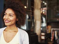 黑人女企业主在敞开的大门前微笑.